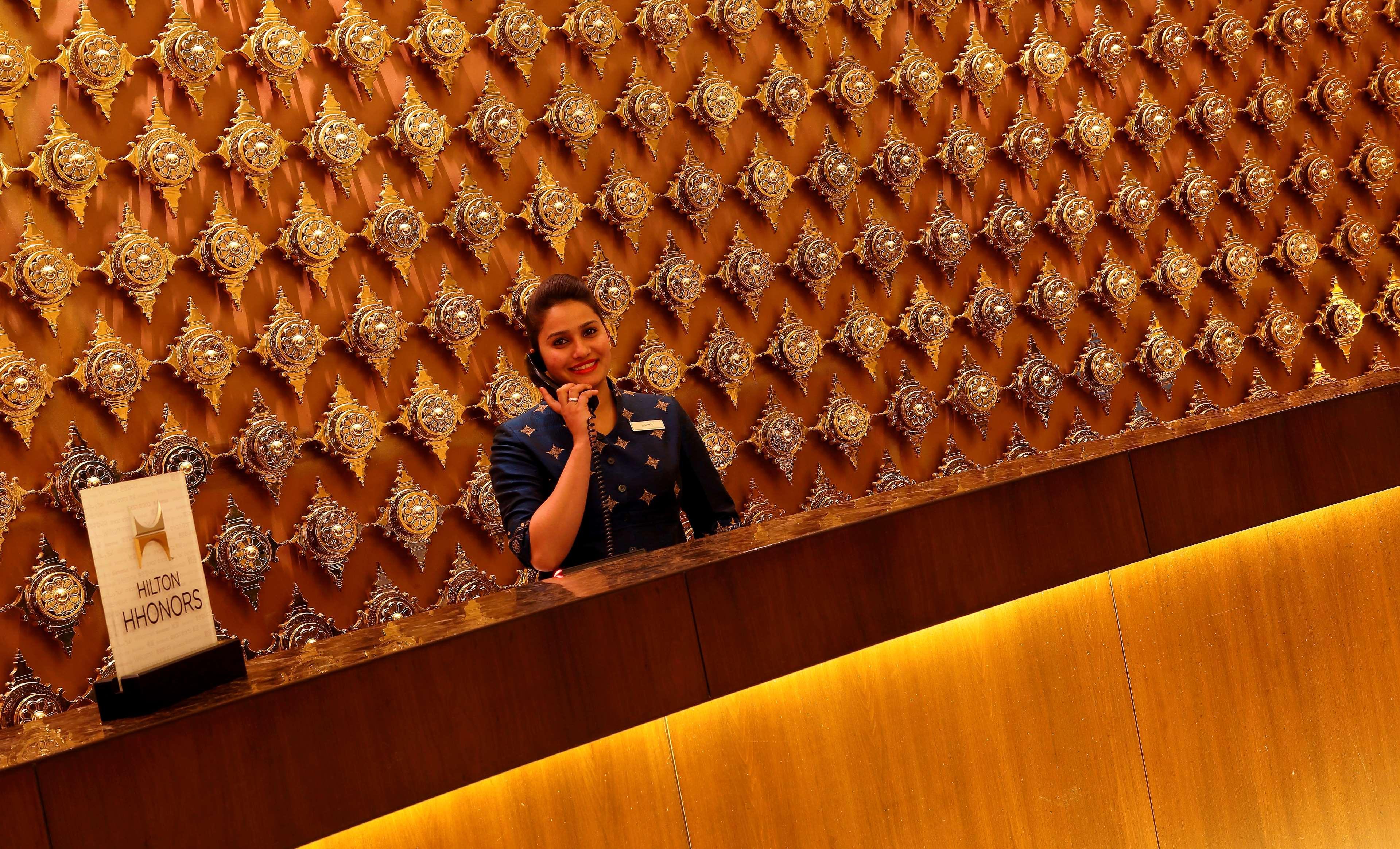 Hilton Jaipur Hotel Exterior foto A hotel receptionist at work